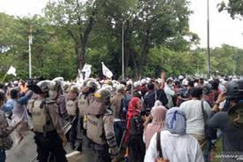 Kepolisian membubarkan massa aksi demonstrasi 1812 yang berkonsentrasi di Patung Kuda, Monas, Gambir, Jakarta Pusat, pada Jumat siang (18/12/2020). (ANTARA/Fianda Sjofjan Rassat)