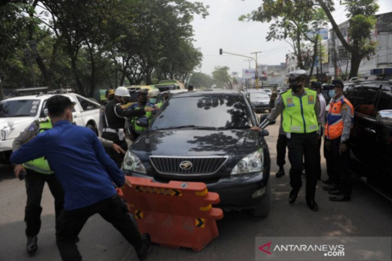 Petugas gabungan menahan mobil yang mencoba kabur dari pemeriksaan di posko penyekatan KM 12 Palembang, Sumsel, Sabtu (8/5/2021). (ANTARA/Feny Selly/21)