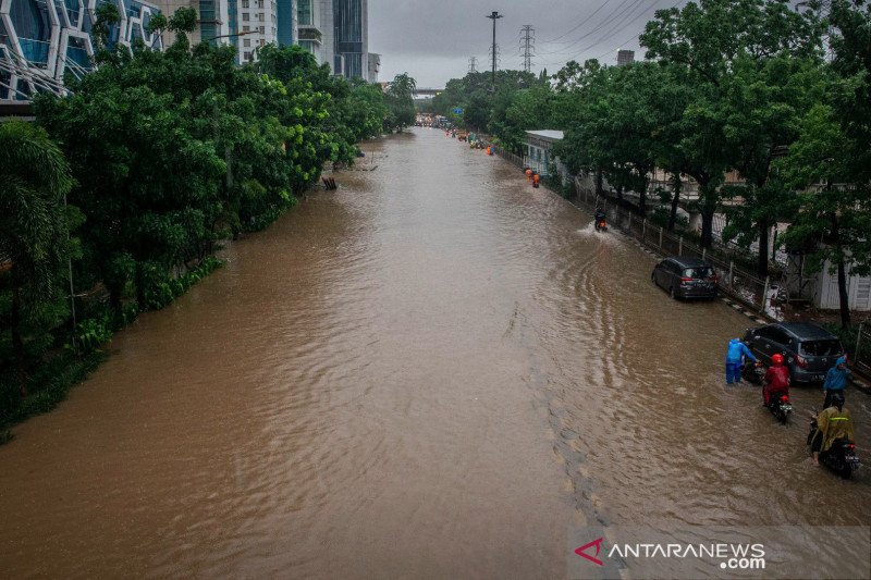 Warga mendorong motornya melintasi genangan banjir di Jalan DI Panjaitan, Cawang, Rabu (1/1/2020). ANTARA FOTO/Aprillio Akbar/pras.