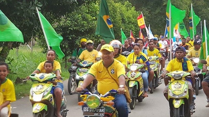 Warga Papu berpawai dengan menggunakan bendera Brazil