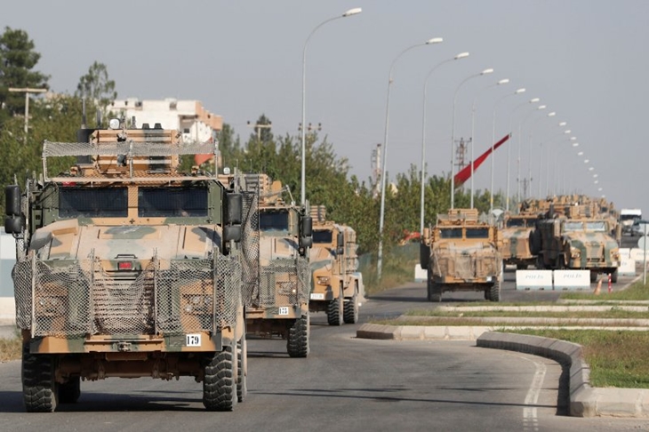 Tentara gerilyawan Suriah dukungan Turki mengibarkan bendera oposisi Suriah di kota perbatasan Tal Abyad, Suriah, Senin (14/10/2019). (REUTERS/Khalil Ashawi)