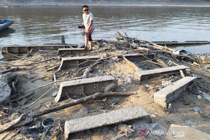 Seorang warga berada di atas bangkai Kapal Onrust yang hampir tertimbun lumpur dan tanah yang hanya bisa dilihat saat Sungai Barito surut kemarau panjang seperti saat ini di kawasan Lalutung Tour 2 km hilir Muara Teweh, Ahad (22/9/2019). (ANTARA/Kasriadi)