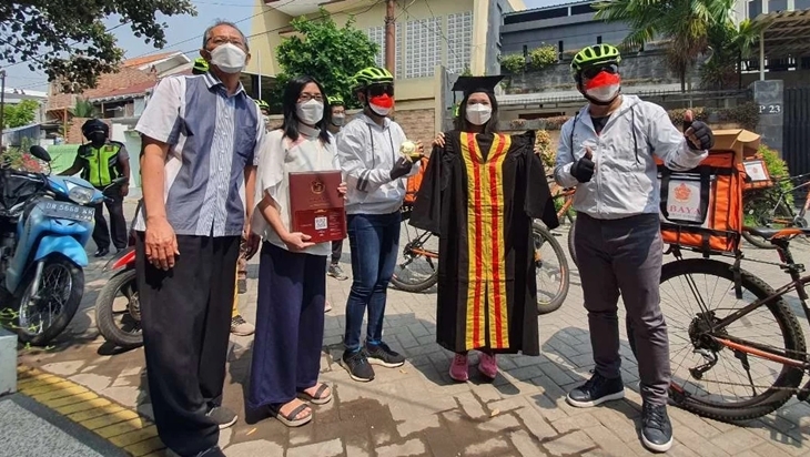 Penyerahan toga ke salah satu mahasiswa yang akan diwisuda di kampus Ubaya Tenggilis Surabaya. (Foto: MP/Dok Humas Ubaya)