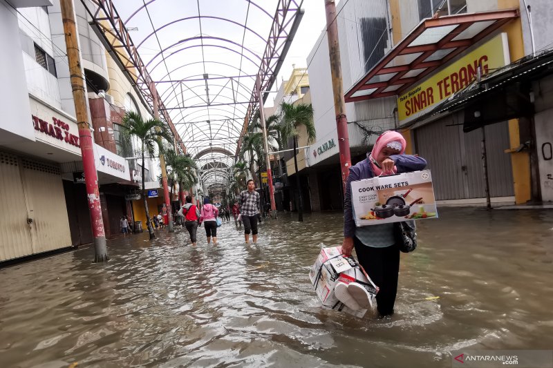 Warga melintasi banjir menggenangi pertokoan Pasar Baru, Jakarta Pusat, Selasa (25/2/2020). Tingginya intensitas hujan mengakibatkan sejumlah wilayah di ibu kota terendam banjir. ANTARA FOTO/Fanny Octavianus/pras.Om