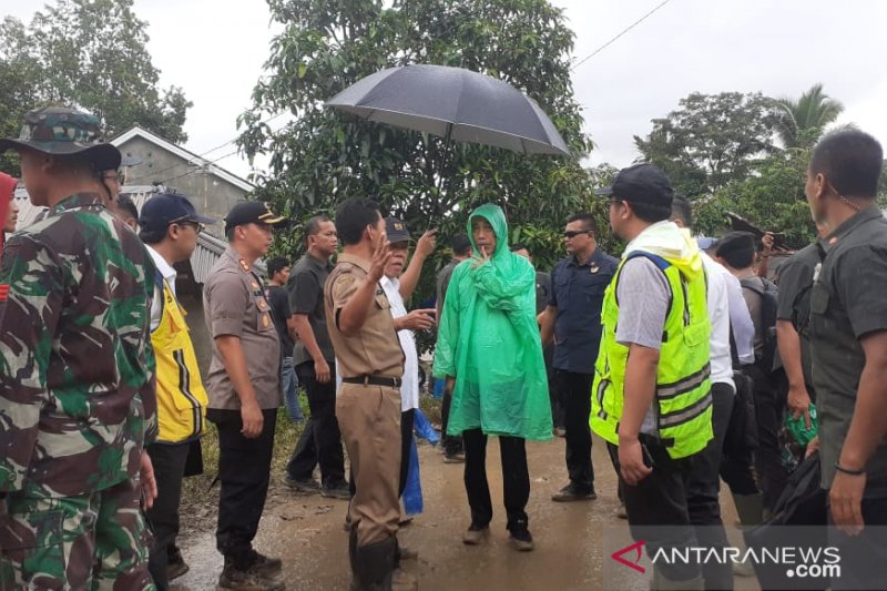 Presiden Jokowi nampak menggunakan jas hujan plastik saat meninjau lokasi tersampak longsor di Desa Harkat Jaya, Kecamatan Sukajaya, Kabupaten Bogor, Jawa Barat, Selasa (7/1/2020). (ANTARA/M Fikri Setiawan)
