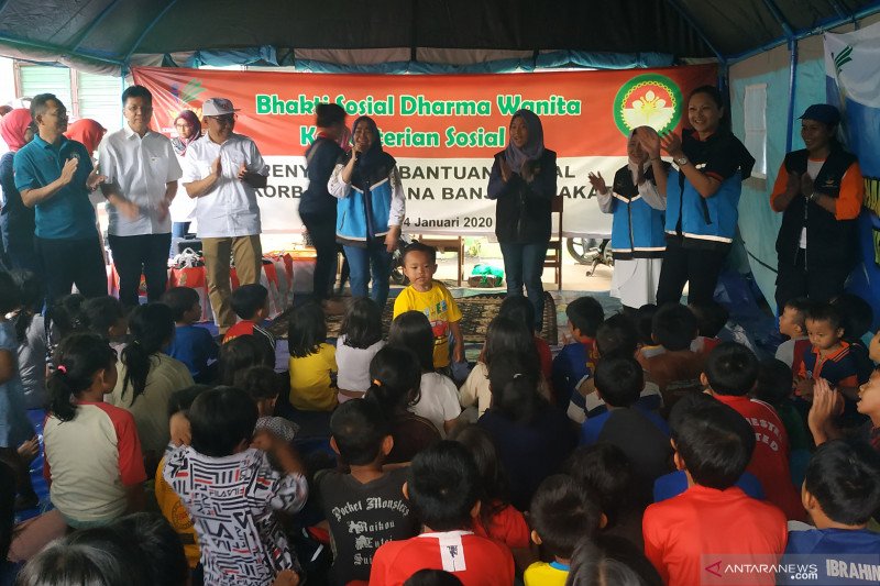 Istri Menteri Sosial Grace Juliari Batubara (dua dari kanan) bernyanyi bersama anak-anak di posko pengungsian di MTs Aljihadiyah Bintaro, Jakarta Selatan, Sabtu (4/1/2020). (FOTO ANTARA/Desi Purnamawati)