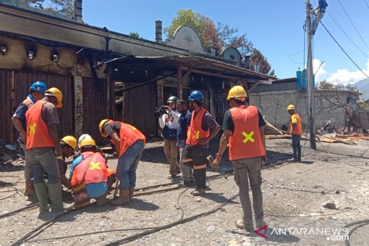 Petugas PLN saat memperbaiki instalasi listrik yang terkena dampak kerusuhan di Jayawijaya. (ANTARA News Papua/Marius Frisson Yewun)