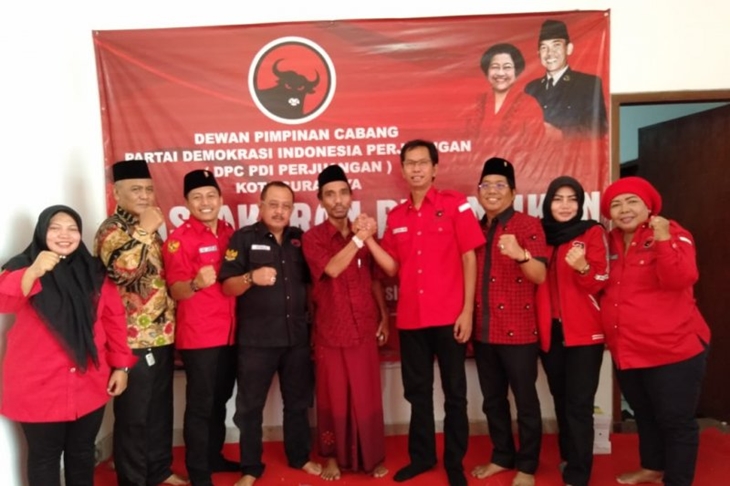 Ketua DPC PDI Perjuangan Surabaya, Adi Sutarwijono dan Ketua PCNU Surabaya, Achmad Muhibbin Zuhri bergenggaman tangan usai acara tasyakuran atas pelantikan Presiden dan Wakil Presiden RI Joko Widodo dan Ma'ruf Amin di kantor DPC PDI Perjuangan Surabaya, Minggu (20/10/2019). (Antara/Abdul Hakim)