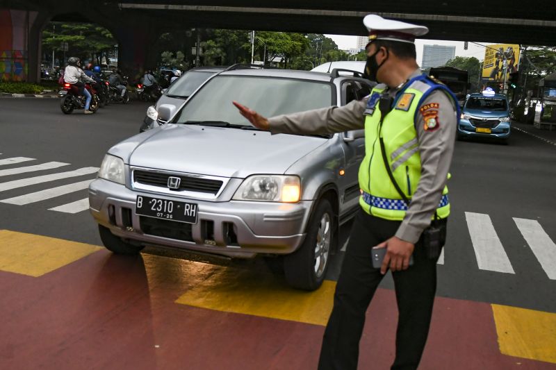 Petugas Kepolisian mensosialisasikan aturan penerapan sistem ganjil-genap kepada pengendara di Jalan Farmawati, Jakarta, Senin (25/10/2021). ANTARA FOTO/Galih Pradipta