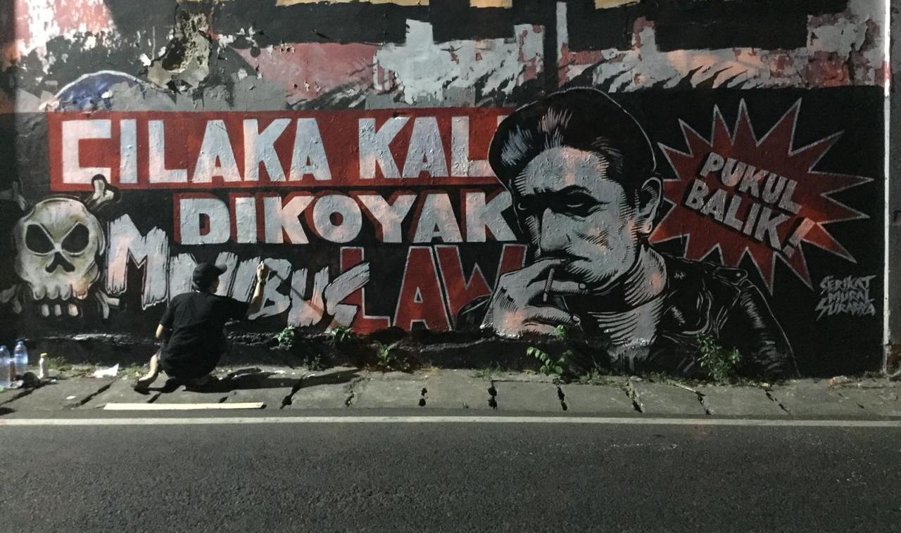 Bentuk protes terhadap Omnibus Law melalui karya Mural yang disampaikan oleh Serikat Mural Surabaya. Foto: MP/Andika Eldon
