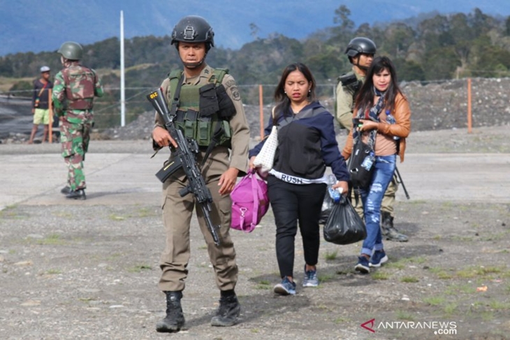  Warga mengungsi dengan penjagaan aparat keamanan di Bandara Ilaga, Kabupaten Puncak, Papua, Selasa (1/10/2019). Warga Ilaga, Kabupaten Puncak, mengungsi menyusul teror penembakan dan pembakaran yang dilakukan oleh kelompok sipil bersenjata. ANTARA FOTO/Sevianto Pakiding/wpa/ama.