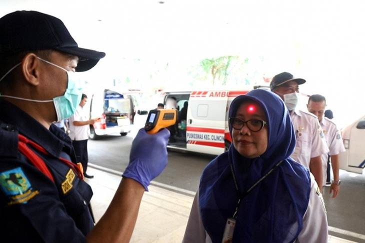 Petugas pengamanan dalam (Pamdal) Kantor Wali Kota Jakarta Utara melakukan pengecekan suhu tubuh karyawan yang masuk ke gedung wali kota, Rabu (4/3/2020). (ANTARA/HO-Kominfotik Jakarta Utara)