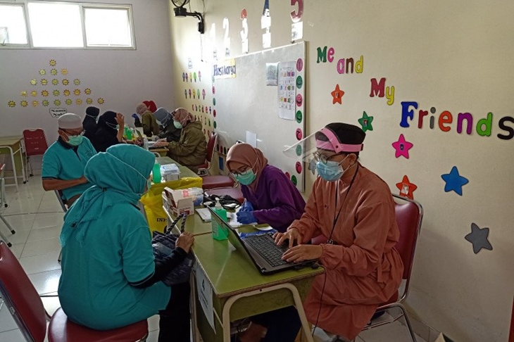 Petugas kesehatan melayani warga lansia menjalani vaksinasi COVID-19 di ruang kelas Taman Kanak-Kanak Al Muhazirin, Pondok Kopi, Jakarta Timur, Senin (8/3/2021). (ANTARA/Andi Firdaus).
