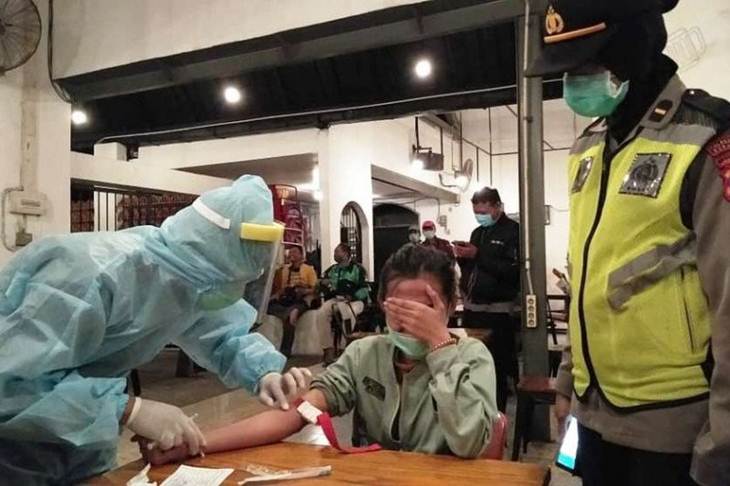 Tim kesehatan saat melakukan "rapid test" untuk mendeteksi COVID-19 kepada salah seorang pengunjung kafe di Kota Surabaya, Senin (13/4/2020) malam. (FOTO ANTARA/HO-Humas Pemprov Jatim/FA)