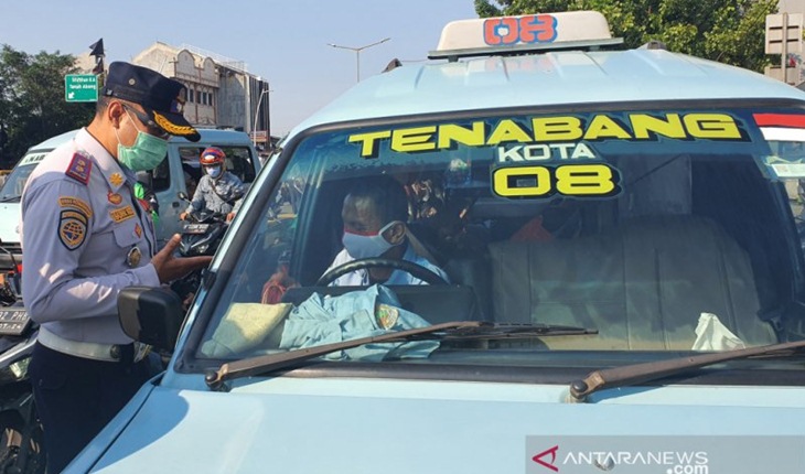 Petugas dari Dishub DKI menghentikan angkot yang kedapatan melanggar aturan pembatasan kapasitas penumpang sebanyak 50 persen dalam Operasi Yustisisi, Senin (21/9). Foto: ANTARA/Livia Kristianti