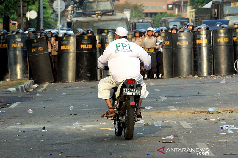Seorang peserta aksi dari Front Pembela Islam (FPI) mengendarai motor di antara penjagaan aparat kepolisian saat aksi demo memprotes film 'Innocence of Muslims' di Kedutaan Amerika Serikat, Jakarta, Senin (17/9/2012). Aksi demo sendiri berakhir ricuh dan mengakibatkan beberapa peserta aksi dan aparat kepolisian terluka. FOTO ANTARA/ Dhoni Setiawan/ed/ama/aa. (ANTARAFOTO/DHONI SETIAWAN)