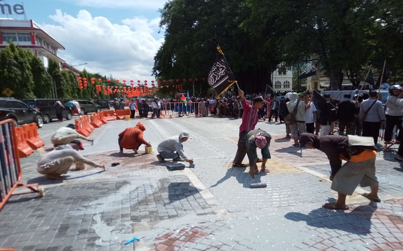 Massa menghapus paving dengan ornamen simbol agama di Solo