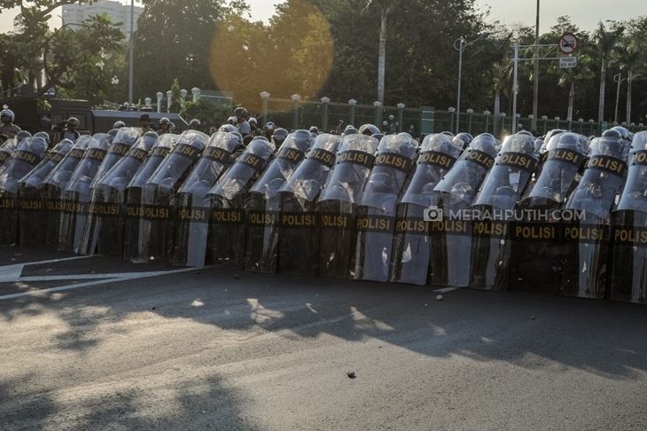 Petugas kepolisian mengawal demonstran di depan Gedung DPR, Jakarta, Senin, (30/9). (Foto: merahputih.com/Rizki Fitrianto