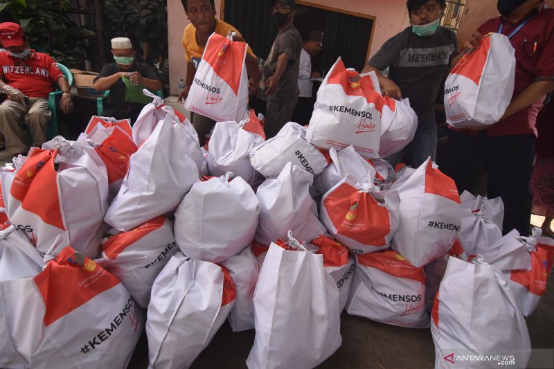 Petugas dibantu warga menurunkan paket sembako yang diberikan Kementerian Sosial (Kemensos) kepada warga yang membutuhkan di kawasan Kebon Baru, Tebet, Jakarta, Rabu (8/4/2020). Kemensos mendistribusikan 200 ribu paket sembako dan makanan siap saji untuk pekerja sektor informal di wilayah zona merah COVID-19. ANTARA FOTO/Indrianto Eko Suwarso/foc.