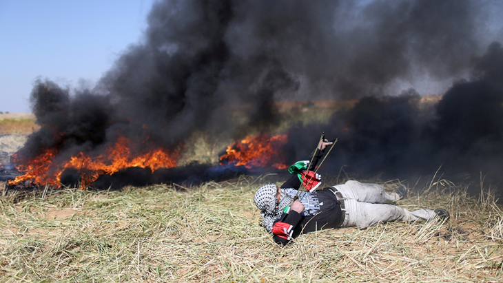 Seorang pemuda Palestina melontarkan batu ke arah pasukan Israel saat terjadi bentrok di perbatasan Gaza-Israel dalam aksi protes menuntut hak untuk kembali ke kampung halaman mereka, di selatan Jalur Gaza, Sabtu (31/3). ANTARA FOTO/REUTERS/Ibraheem Abu Mustafa/djo/18