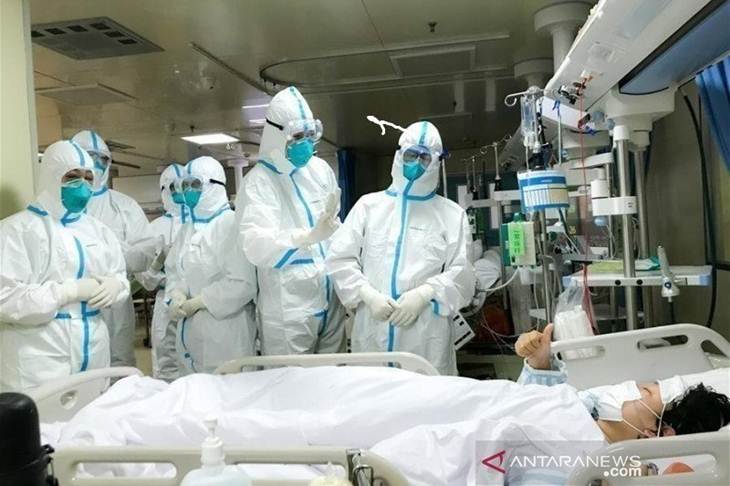 Seorang pasien 2019-nCoV di Rumah Sakit Hankou, Wuhan, memberikan isyarat jempol kepada tim kesehatan dari Second Military Medical University, Senin (27/1/2020). (ANTARA/HO-ChinaNews)