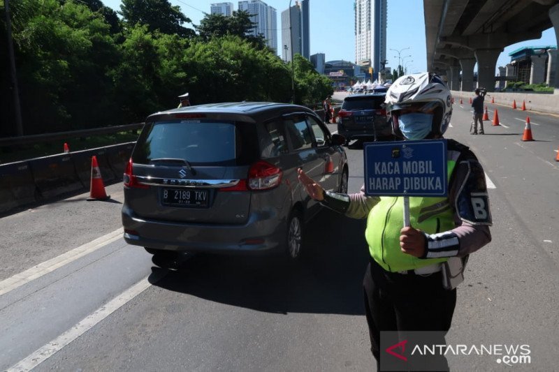 Petugas Kepolisian meminta pengendaraan membuka kaca jendela saat melintasi pos penyekatan arus mudik di jalan tol Jakarta-Cikampek, Bekasi, Jawa Barat. (ANTARA/Sugiharto Purnama)