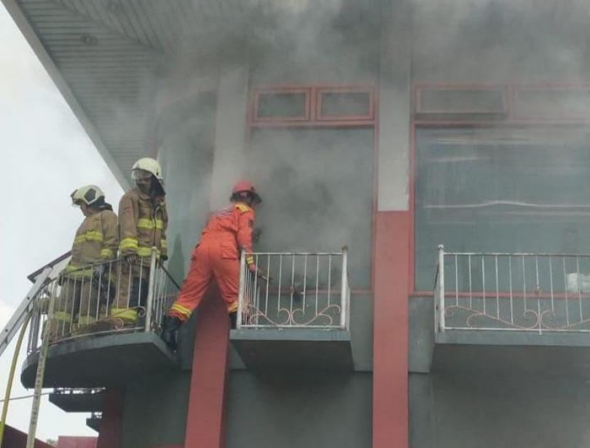 Petugas sedang memadamkan api yang membakar gedung kantor SPBU Pertamina di Jalan Pramuka Raya, Senen, Jakarta Pusat, Rabu (2/6). Foto: Gulkarmat Jakpus