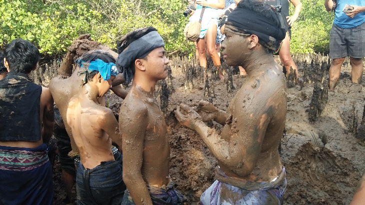 Warga saling melaburi badan dengan lumpur