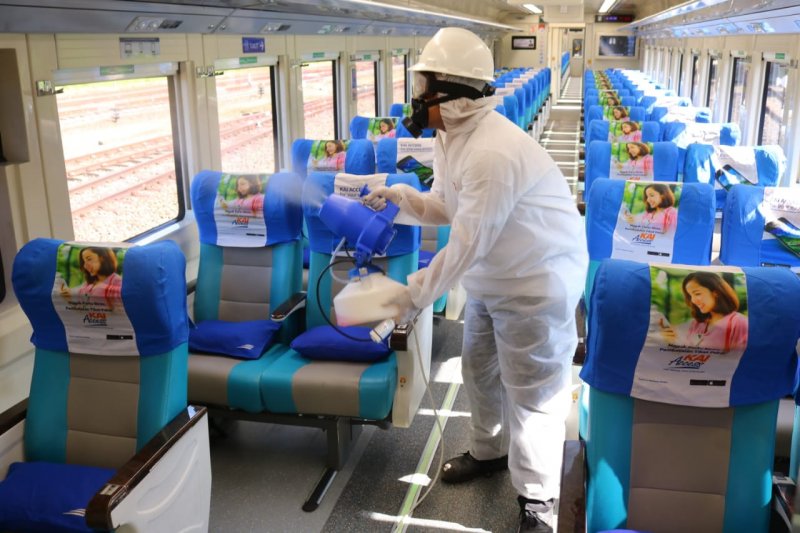 Petugas menyemprotkan cairan disinfektan ke kursi penumpang KA. (KAI)