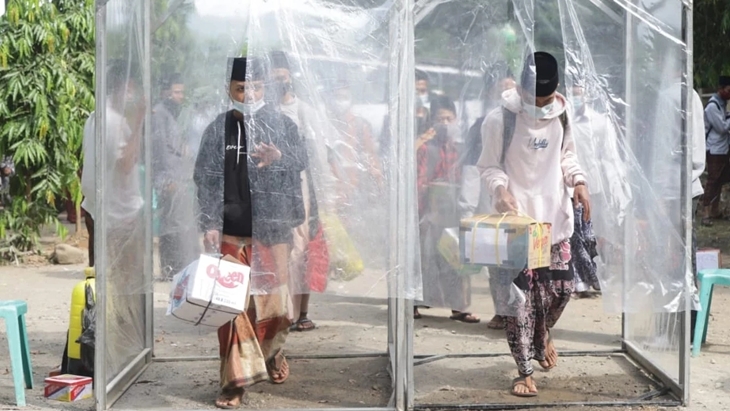 Para santri saat melewati bilik debgan penyemprotan disinfektan. (Foto: MP/Istimewa)