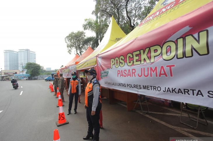 Petugas gabungan berjaga saat penyekatan larangan mudik lebaran 2021 di perbatasan pos pemeriksaan sekitar Pasar Jumat, Lebak Bulus, Jakarta, Rabu (12/5/2021). ANTARA FOTO/ Reno Esnir/nz (ANTARA/RENO ESNIR)