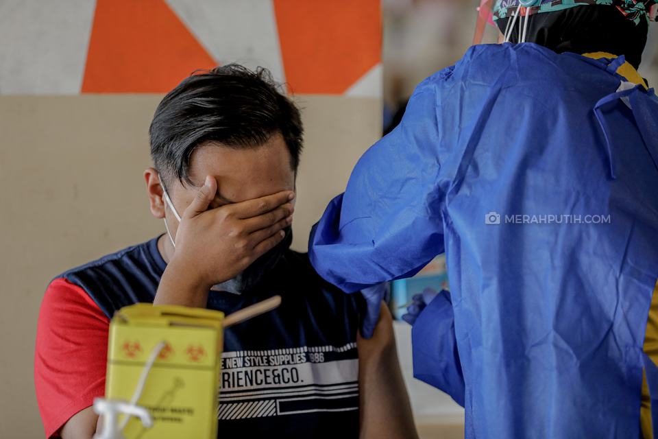 Vaksinator menyuntikkan vaksin COVID-19 kepada pedagang saat vaksinasi di Summarecon Mall Serpong, Kabupaten Tangerang, Banten, Selasa (9/3/2021). Sebanyak 1.000 pedagang pasar di Kabupaten Tangerang menjalani vaksinasi COVID-19 tahap pertama. Merahputih.com / Rizki Fitrianto