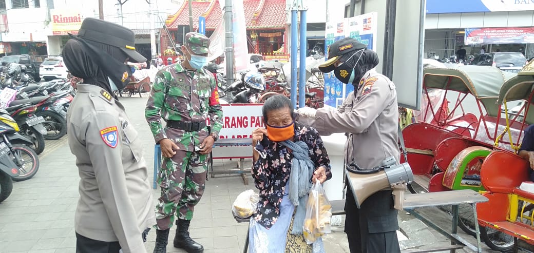 Anggota TNI dan Polri di Solo, Jawa Tengah membagikan masker pada masyarakat, Senin (1/2). (MP/Ismail)