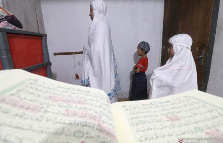 Seorang ibu bersama dua anaknya melakukan shalat berjamaah di rumahnya di Kota Kediri, Jawa Timur, Senin (30/3/2020). ANTARA FOTO/Prasetia Fauzani/foc.