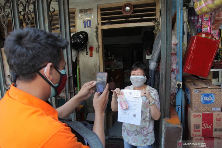 Petugas mendokumentasikan distribusi Bantuan Sosial Tunai (BST) secara pintu ke pintu di kawasan Pecinan Glodok, Jakarta, Minggu (25/7/2021). . ANTARA FOTO/Reno Esnir/rwa. (ANTARA/RENO ESNIR)