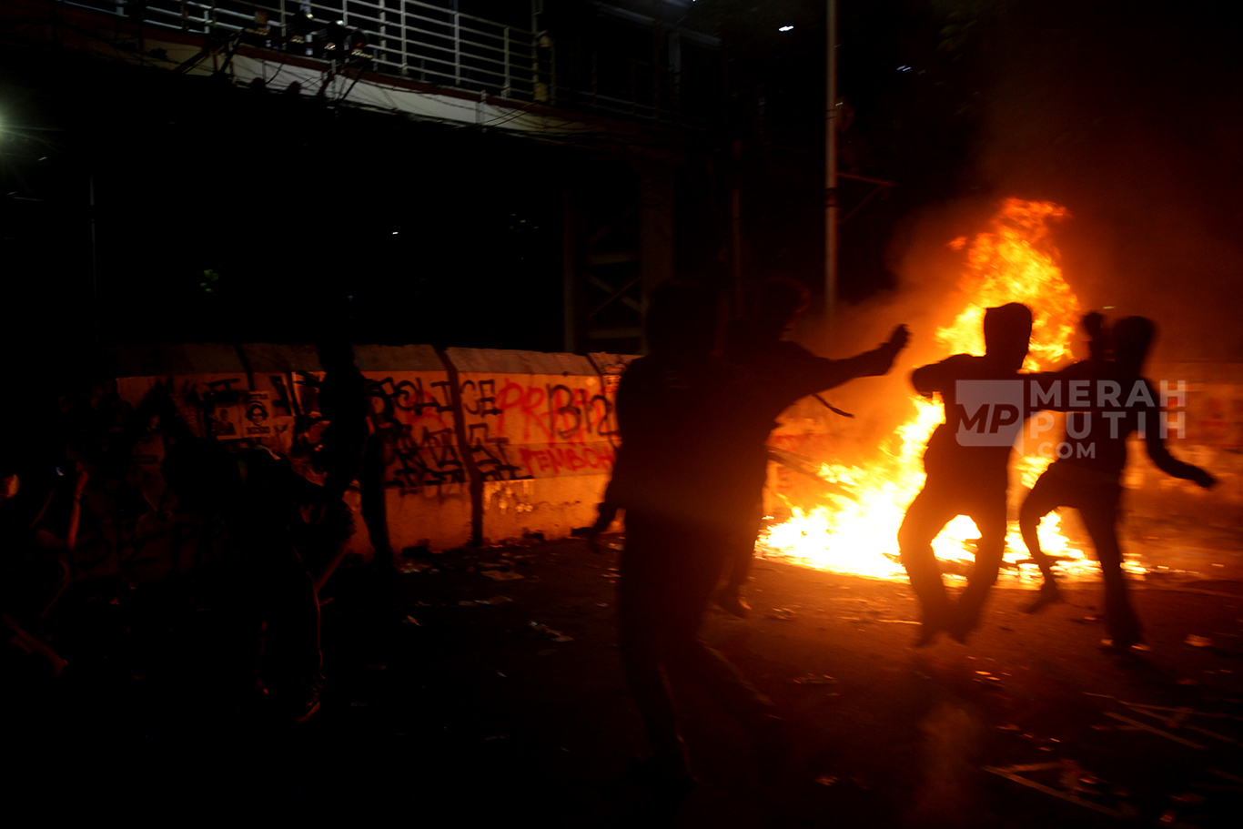 Aksi mahasiswa melempar batu ke arah polisi dalam aksi demo Indonesia Gelap di Patung Kuda, Silang Monas, Jakarta, Jum'at (21/2/2025).