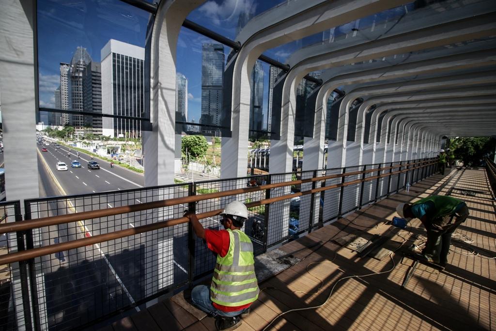 Pekerja menggarap proyek pembangunan Jembatan Penyeberangan Orang (JPO) Bundaran Senayan, Jakarta, Kamis (3/1). Pembangunan JPO yang menelan anggaran sebesar 17,4 miliar rupiah ini ditargetkan akan selesai pada pertengahan bulan Januari.