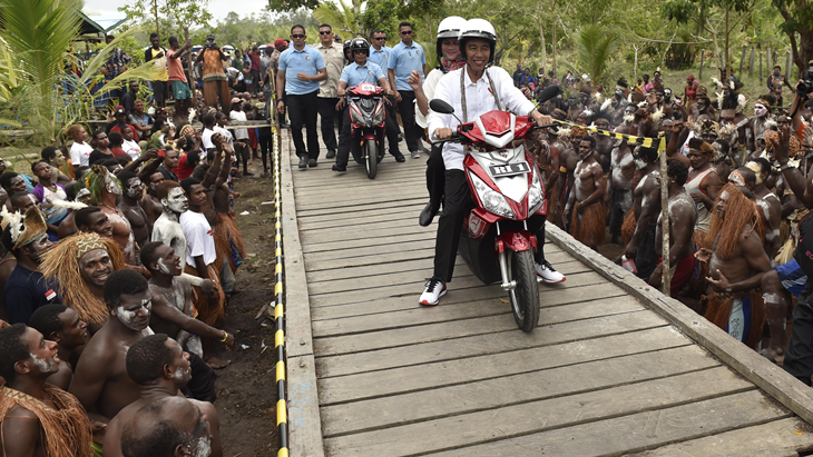 Presiden Joko Widodo berboncengan dengan Ibu Negara Iriana Joko Widodo menggunakan motor listrik menyapa warga Asmat saat kunjungan kerja di Kampung Kaye, Distrik Agats, Kabupaten Asmat, Papua, Kamis (12/4). Kunjungan kerja Presiden ke Asmat diantaranya untuk pemberian gizi makanan tambahan bagi ibu hamil dan anak-anak, memeriksa pembangunan tampungan air hujan serta pembangunan rumah bagi warga Asmat. ANTARA FOTO/Puspa Perwitasari/ama/18