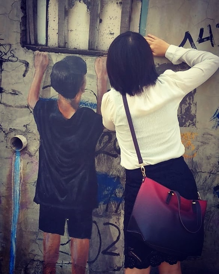 Pengunjung berfoto di tembok bermural di Jalan Parkit. (Foto: instagram.com/tan.santi)