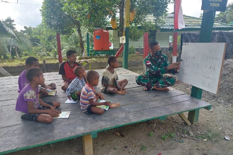 TNI Bagikan Buku dan Ajari Anak di Perbatasan Papua-PNG Baca Tulis