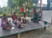 TNI Bagikan Buku dan Ajari Anak di Perbatasan Papua-PNG Baca Tulis