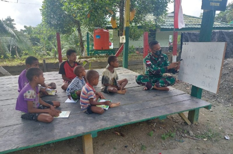 TNI Bagikan Buku dan Ajari Anak di Perbatasan Papua-PNG Baca Tulis