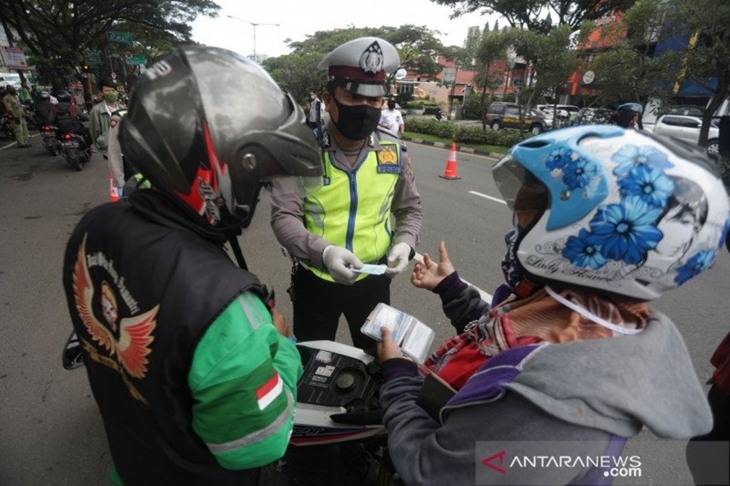 Polisi melakukan pemeriksaan pada pengguna jalan pada masa penerapan pembatasan sosial berskala besar untuk mengendalikan penularan COVID-19. (ANTARA/HO-Humas Pemkot Bandung)