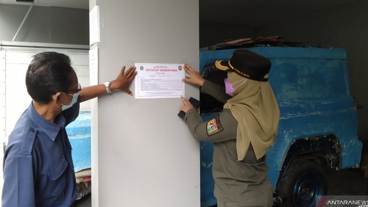 Satpol PP Kelurahan Pulo, Jakarta Selatan, memasang stiker penutupan sementara rumah indekos selama 3x24 jam karena satu penghuni positif COVID-19, Kamis (17/6/2021). (ANTARA/Dewa Ketut Sudiarta Wiguna)