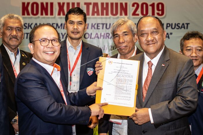 Ketua Umum KONI Pusat Letjen TNI (Purn) Marciano Norman (kanan depan) menerima surat keputusan dari pimpinan sidang Djamhuron P Wibowo (kiri depan) dalam Musyawarah Olahraga Nasional (Musornas) KONI XIII tahun 2019 di Jakarta, Selasa (2/7/2019). (Antara)
