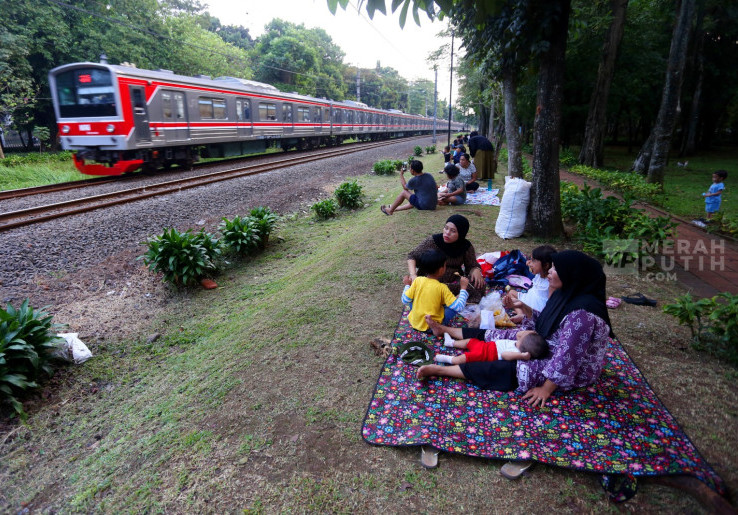 Libur Akhir Pekan, Warga Piknik Sambil Menikmati Lalu Lalang KRL di Taman Tanah Kusir