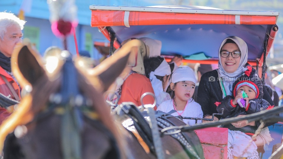 Peserta anak gimbal didampingi orangtuanya menaiki andong untuk mengikuti kirab keliling kampung (MP/Rizki Fitrianto)