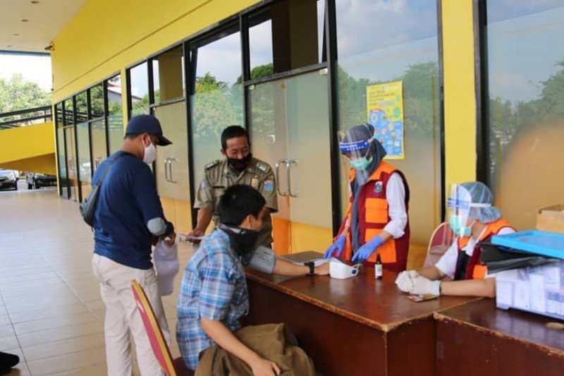 Petugas Suku Dinas Perhubungan dan Satpol PP Jakarta Timur mendata identitas pendatang tanpa surat izin keluar masuk (SIKM) saat akan dikarantina di GOR Rawamangun, Pulogadung, Jakarta Timur, Rabu (3/5/2020). (ANTARA/HO-Sudinhub Jaktim).
