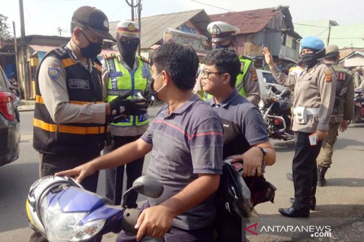 Petugas Polres Bogor saat melakukan pengawasan di check point PSBB. (ANTARA/M Fikri Setiawan)