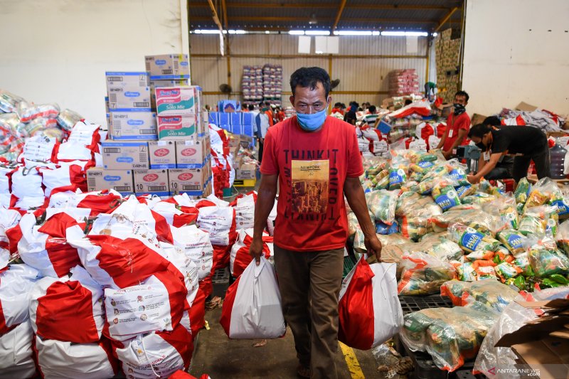 Pekerja membawa paket bantuan sosial (bansos) yang akan disalurkan di Gudang Food Station Cipinang, Jakarta, Rabu (22/4/2020). ANTARA FOTO/M Risyal Hidayat/aww. (ANTARA FOTO/M RISYAL HIDAYAT)